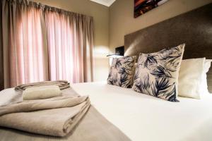 une chambre avec un lit avec deux oreillers dans l'établissement Meadowbrook Guesthouse, à Pretoria
