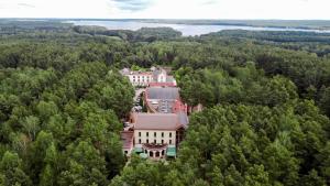 uma vista aérea de um edifício nas árvores em Hotel Magellan em Bronisławów
