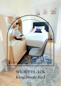1 dormitorio pequeño con 1 cama y 1 silla en Black Coffee House en Auckland
