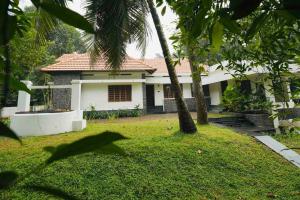 a house with a palm tree in the yard at Thekkaniyil Homestay in Kottayam