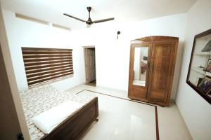 a bedroom with a bed and a ceiling fan at Thekkaniyil Homestay in Kottayam