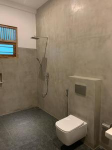 La salle de bains est pourvue d'une douche et de toilettes. dans l'établissement Eton Villa, à Dikwella