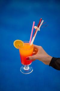 une main tenant une boisson avec une tranche de citron dans l'établissement Sunset Beach Club Aqua Lettings, à Fethiye