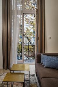 - un salon avec un canapé et une grande fenêtre dans l'établissement VN48 Suites by Adrez, à Prague