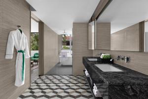 a bathroom with a sink and a mirror at Madi Paidi Bangkok, Autograph Collection in Bangkok