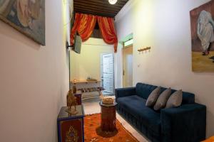 een woonkamer met een blauwe bank en een tafel bij RIAD AMR in Tanger