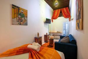 een slaapkamer met een bed en een bank bij RIAD AMR in Tanger