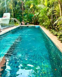 a swimming pool with blue water in a yard at Anjuna- Villa near Vagator beach with pvt pool in Vagator