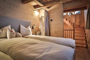 a bedroom with two beds and a staircase at Burgfrieder Mühle in Rasun di Sopra