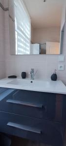 een witte badkamer met een wastafel en een spiegel bij Résidence Bel'Air in Aire-sur-la-Lys