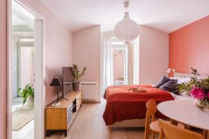a bedroom with a red bed and a table at TurnKey I Letná Park Apartments in Prague