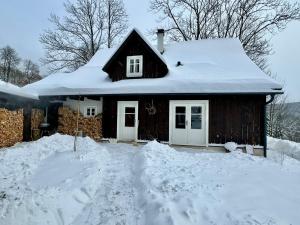 a house with snow on the roof of it at Chaloupka Dvě Sestry in Kořenov