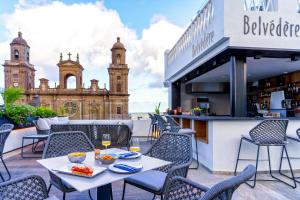an outdoor patio with tables and chairs and a building at Boutique Hotel Cordial Plaza Mayor de Santa Ana in Las Palmas de Gran Canaria
