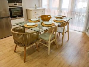 a kitchen with a glass table with chairs and plates on it at Center Granada Apartament Elegant in Granada