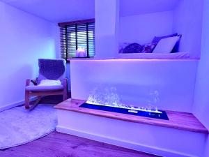 ein Wohnzimmer mit einem Aquarium und einem Stuhl in der Unterkunft Le Zen - Sauna - Balnéo - Sparoom Sarreguemines in Sarreguemines