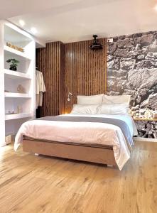 una camera da letto con un grande letto e un muro in pietra di Le Zen - Sauna - Balnéo - Sparoom Sarreguemines a Sarreguemines