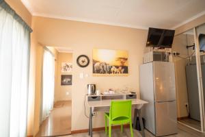 une cuisine avec une table et un réfrigérateur dans l'établissement Meadowbrook Guesthouse, à Pretoria