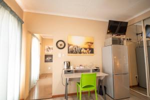 a kitchen with a table and a refrigerator at Meadowbrook Guesthouse in Pretoria