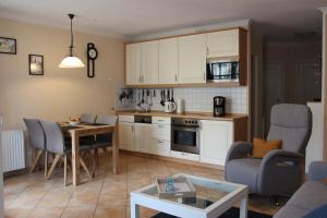uma cozinha e sala de estar com mesa e cadeiras em Haus Atlantik em Kühlungsborn