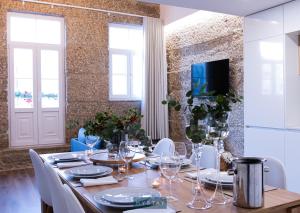 uma sala de jantar com uma mesa longa e cadeiras brancas em MyStay - D Maria Apartments em Vila Nova de Famalicão