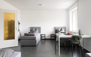 Cette chambre blanche comprend un lit, une table et des chaises. dans l'établissement Moderne Wohnung im Zentrum, à Gronau