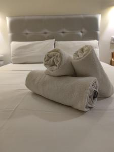 una pila de toallas sentadas en una cama en Good Stay Rooms, en Madrid