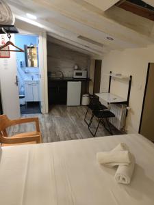 Habitación con cama blanca y cocina en Good Stay Rooms, en Madrid