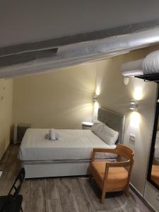 1 dormitorio pequeño con 1 cama y 1 silla en Good Stay Rooms, en Madrid