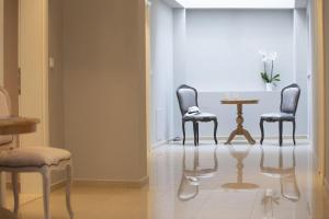 VK Luxury Suites - Private Parking - Adults Only في نيدري: كرسيين وطاولة في الغرفة