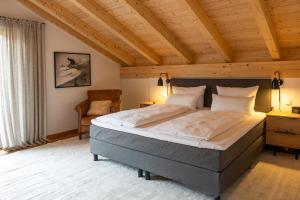 sypialnia z dużym łóżkiem i drewnianym sufitem w obiekcie Aurum Lodge w Garmisch Partenkirchen