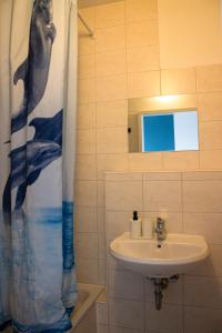 a bathroom with a sink and a shower curtain at Metropol Hostel Berlin in Berlin