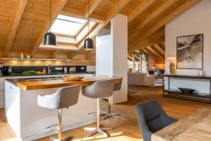 kuchnia z drewnianymi sufitami oraz stołem i krzesłami w obiekcie Aurum Lodge w Garmisch Partenkirchen