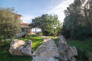 Appartamento Bellavista في Telti: حديقة فيها صخور امام المنزل