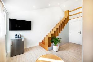 a living room with a staircase and a tv on the wall at Lisbon Oriente Suites by Olala Homes in Lisbon