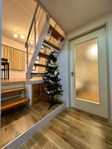 a christmas tree in a room with a staircase at 【NEW OPEN】AMS Hiragishi R401 in Sapporo