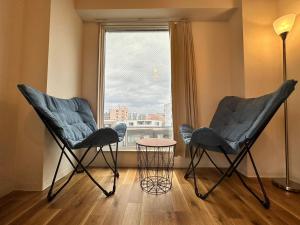 - deux chaises et une table dans une chambre avec fenêtre dans l'établissement 【NEW OPEN】AMS Hiragishi R401, à Sapporo