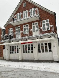 een rood bakstenen gebouw met witte deuren in de sneeuw bij Kegelrobbe in Wyk auf Föhr