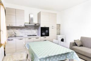a kitchen with white cabinets and a table and a couch at Villino Verde in Mira