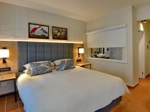 a bedroom with a large white bed and a window at ANEW Resort Hazyview Kruger Park in Hazyview