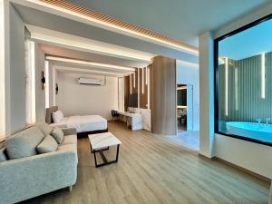 sala de estar con sofá, cama y bañera en Rock Resort Ratchaburi en Ratchaburi