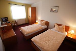 a hotel room with two beds and a window at Eiscafe-Pizzeria-Hotel Rialto in Eilenburg