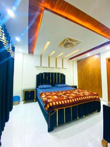 a bedroom with a blue bed in a room at Luxury Apartment in Bahria Town, Lahore in Lahore