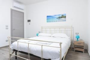 a white bedroom with a bed and a painting on the wall at Villino Verde in Mira