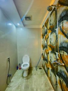 a bathroom with a toilet and a painting on the wall at Luxury Apartment in Bahria Town, Lahore in Lahore