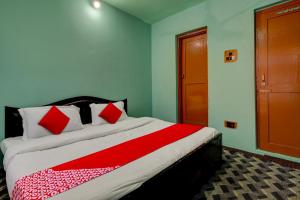 een slaapkamer met een bed met rode en witte kussens bij OYO Flagship Wooden Cave By M2 in Srinagar