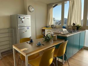 a kitchen with a table and a refrigerator at La Terrazza sui Tetti nel cuore di Torino in Turin
