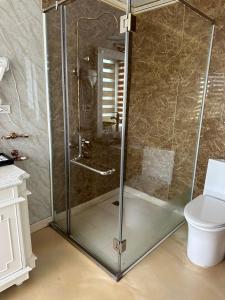 a glass shower in a bathroom with a toilet at Aquamarine Premium Cruise in Ha Long