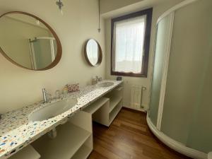 a bathroom with two sinks and a large mirror at La Terrazza sui Tetti nel cuore di Torino in Turin +32 photos