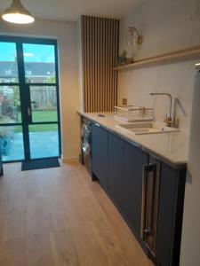 a kitchen with a sink and a washing machine at WELCOMEHOUSE close to east beach, shops, restaurants and RAF base in Lossiemouth