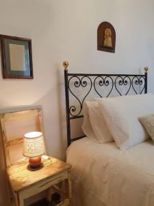 ein Schlafzimmer mit einem Bett und einem Tisch mit einer Lampe in der Unterkunft La casa dei nonni tra Crete Senesi e Val D'Orcia in San Giovanni dʼAsso
